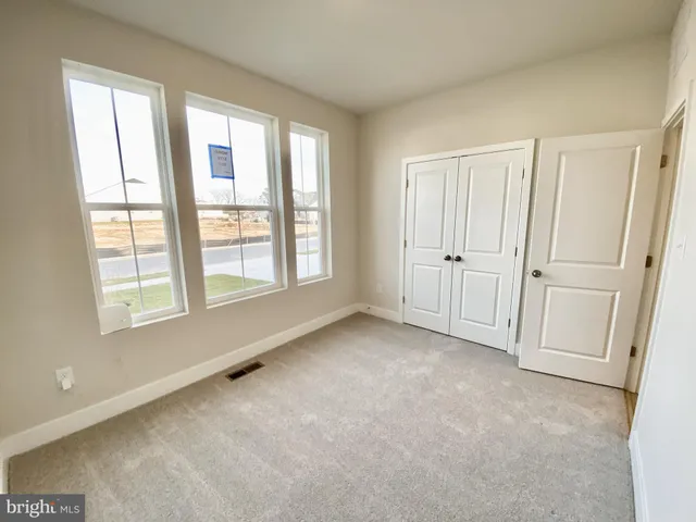 an empty room with windows and closet