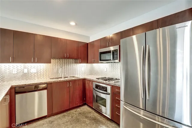 a kitchen with stainless steel appliances granite countertop a refrigerator and a sink