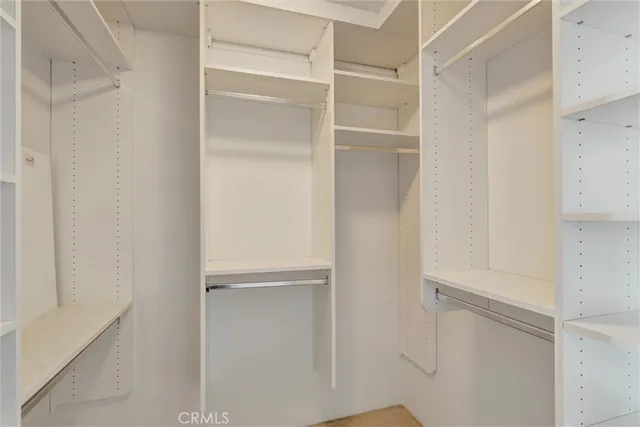 a view of walk in closet with empty racks