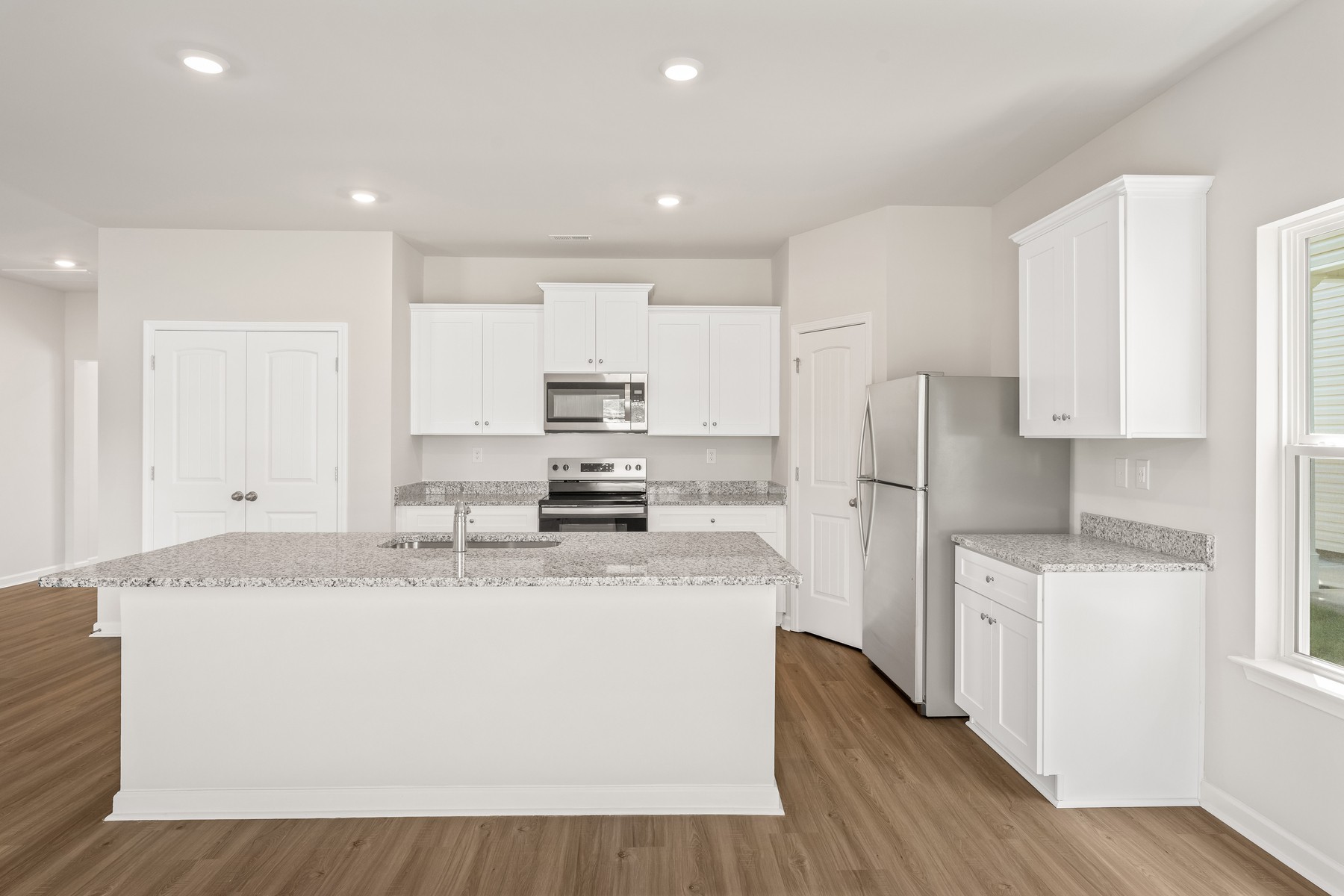 2007 Lala Loop White Bluff, TN 37187 - Photo 6 of 15 a large kitchen with stainless steel appliances granite countertop a stove a refrigerator a sink and white cabinets with wooden floor