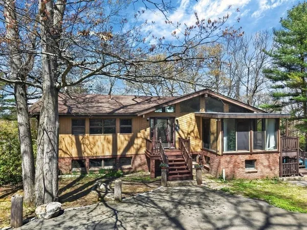 a view of a house with a yard balcony and tree