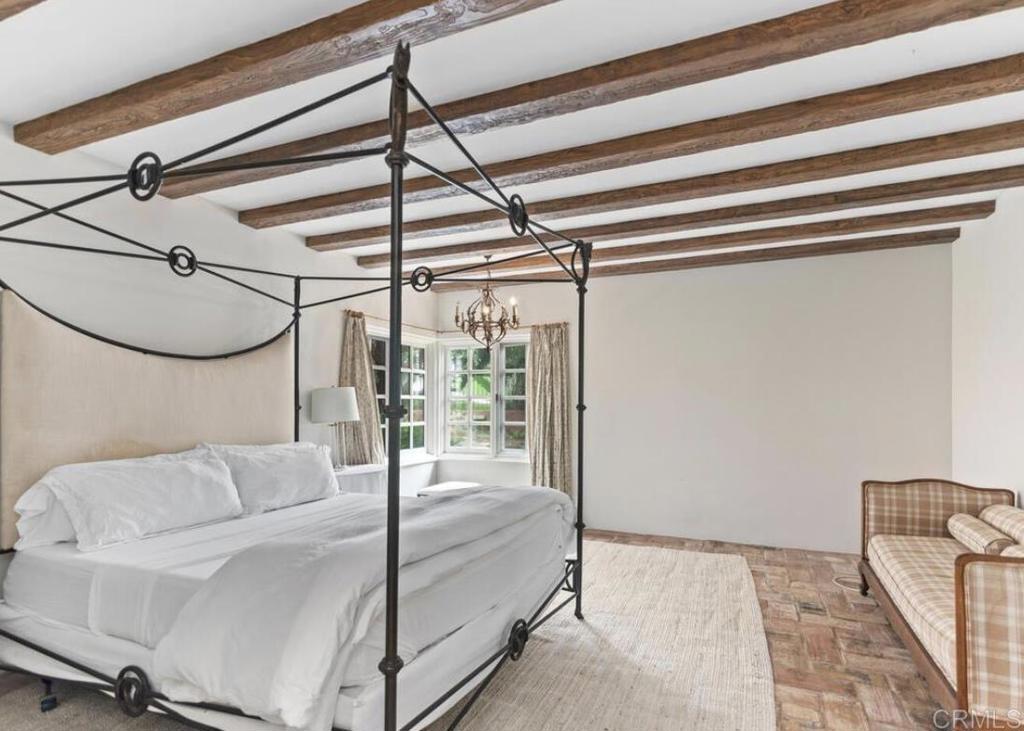 17116 Paseo Hermosa Rancho Santa Fe, CA 92067 - Photo 12 of 28 a bedroom with a bed and a chandelier