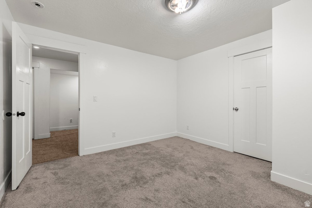 463 South Trejo Ridge Road Grantsville, UT 84029 - Photo 15 of 22 Room featuring light gray carpet flooring, white walls, white trim, and a flush mount ceiling light fixture