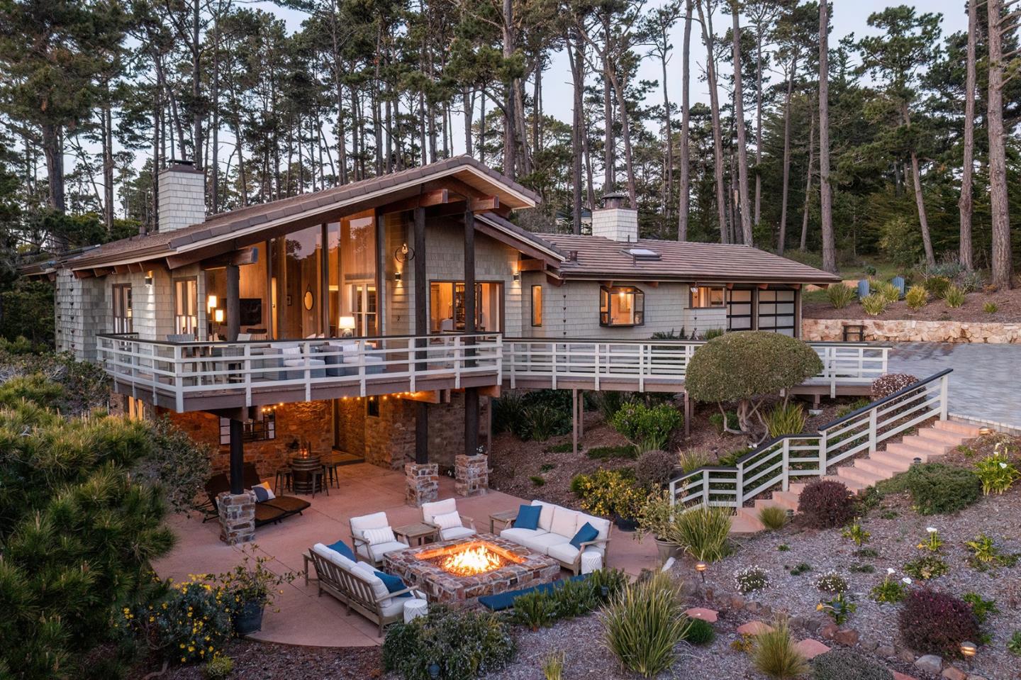 a view of a patio with couches table and chairs under an umbrella