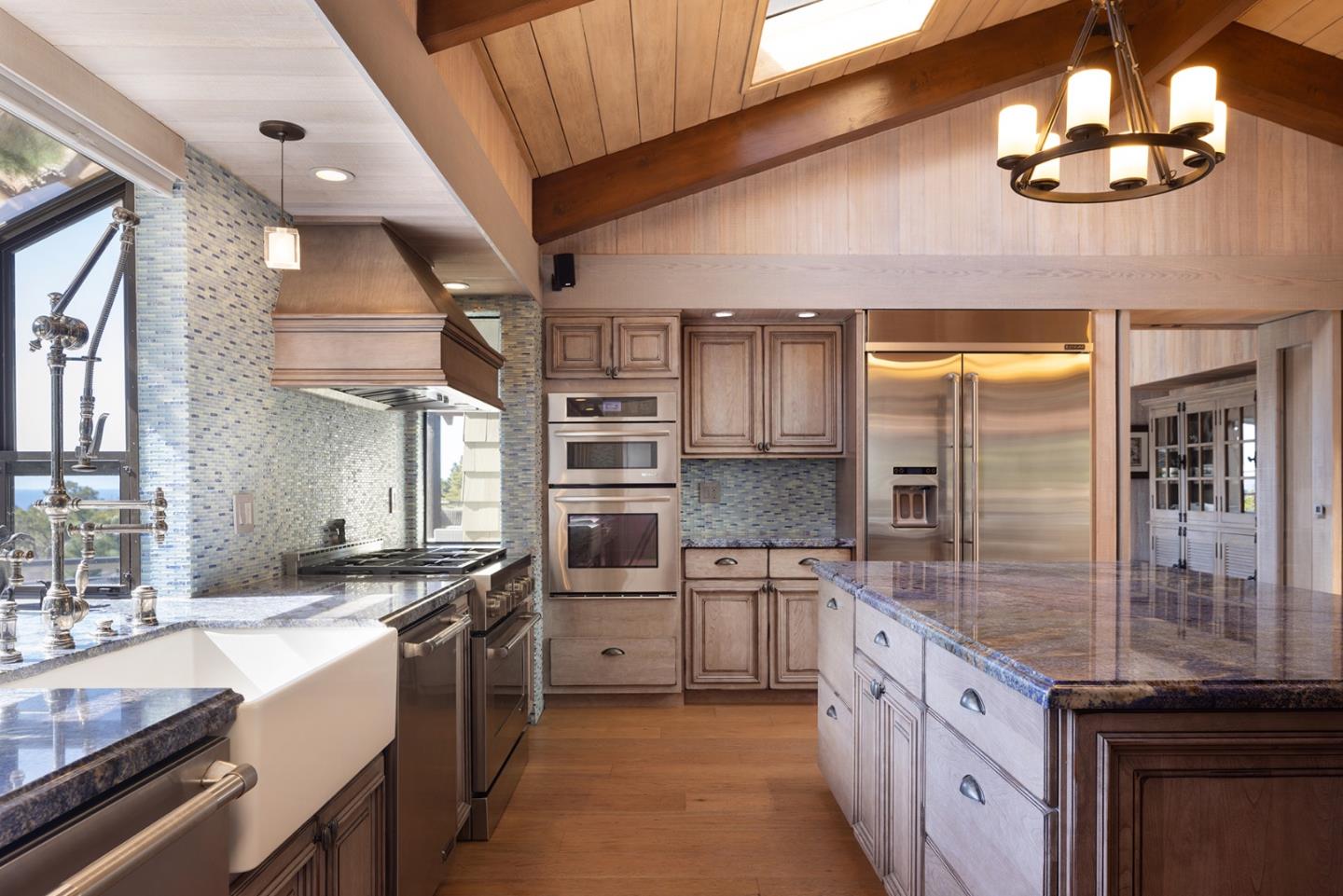 3893 Ronda Road Pebble Beach, CA 93953 - Photo 15 of 48 a large kitchen with stainless steel appliances kitchen island granite countertop a sink and cabinets