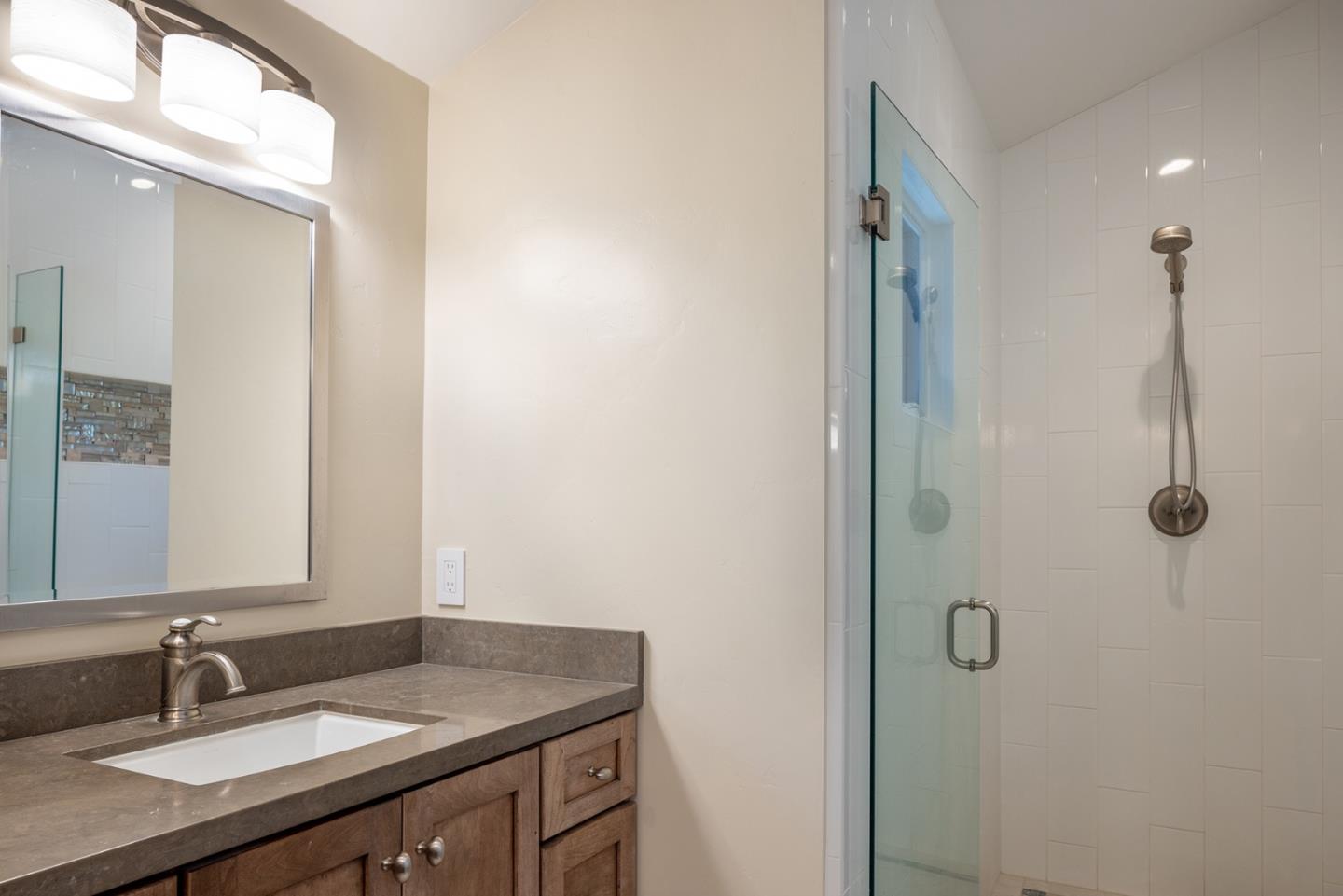 3893 Ronda Road Pebble Beach, CA 93953 - Photo 29 of 48 a bathroom with a granite countertop sink and mirror