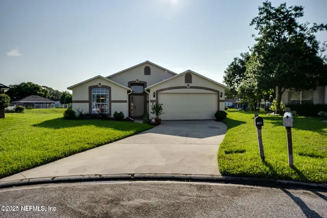 a front view of a house with a yard and trees