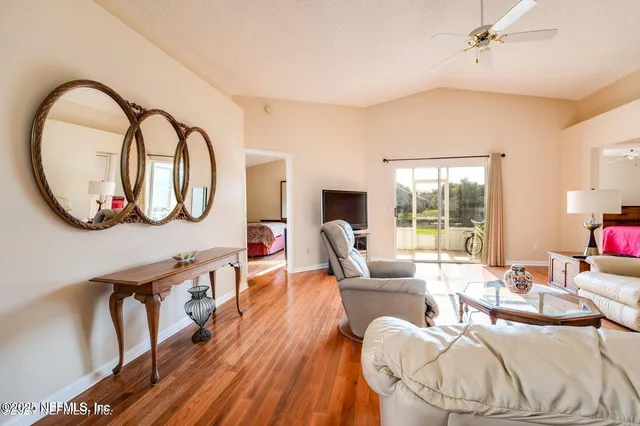 a living room with furniture a mirror and a large window