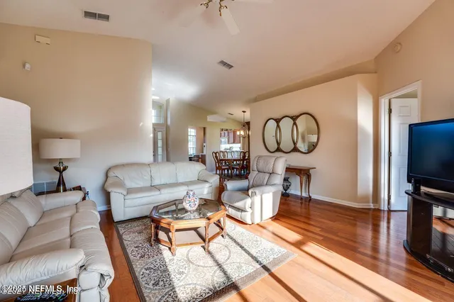 a living room with furniture a flat screen tv and a window