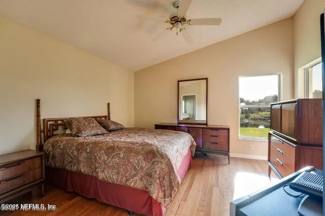 a bedroom with a bed wooden floor and window