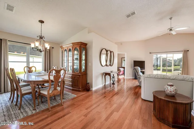 a dining room with furniture a chandelier and wooden floor