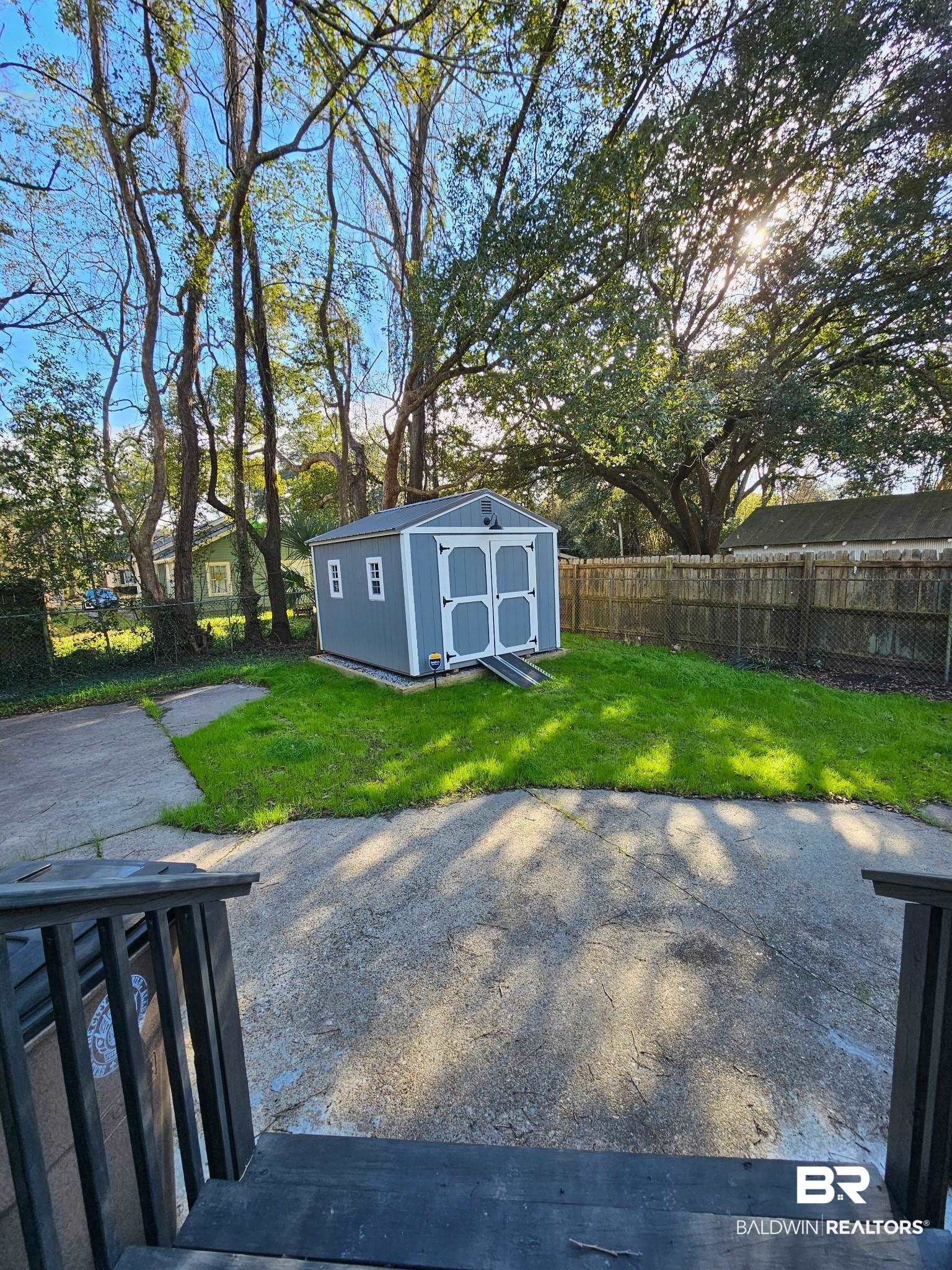 1215 Church Street Mobile, AL 36604 - Photo 22 of 23 View of yard with a fenced backyard, a storage unit, a patio, and an outbuilding