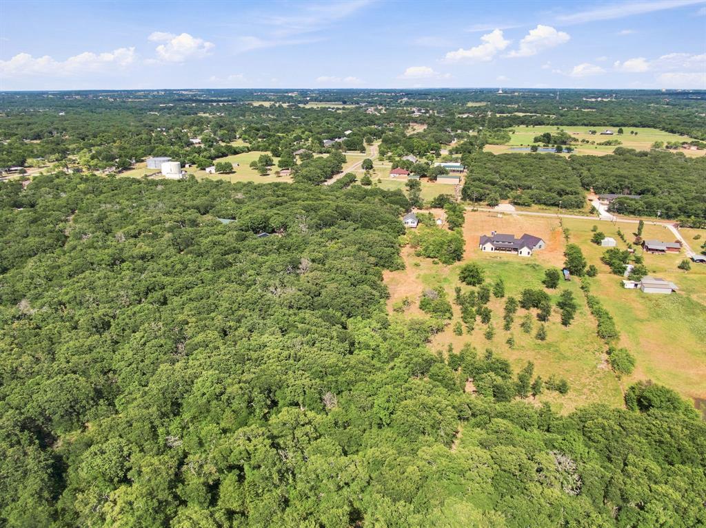 3325 Dove Creek Road Cleburne, TX 76031 - Photo 36 of 40 Expansive tree canopy across the property with partially cleared land featuring a single-story residence