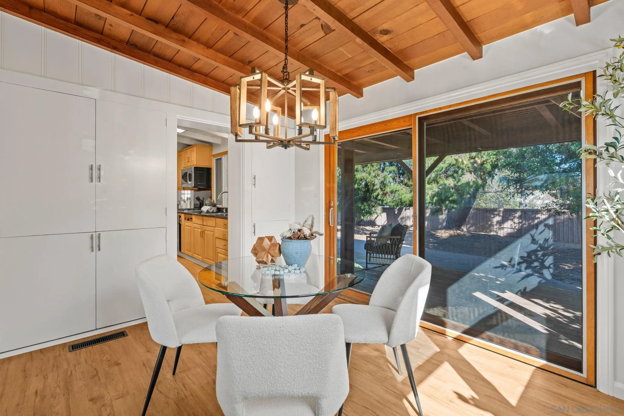 1395 Summit Avenue Cardiff, CA 92007 - Photo 11 of 47 a dining room with wooden floor a chandelier a glass table and chairs