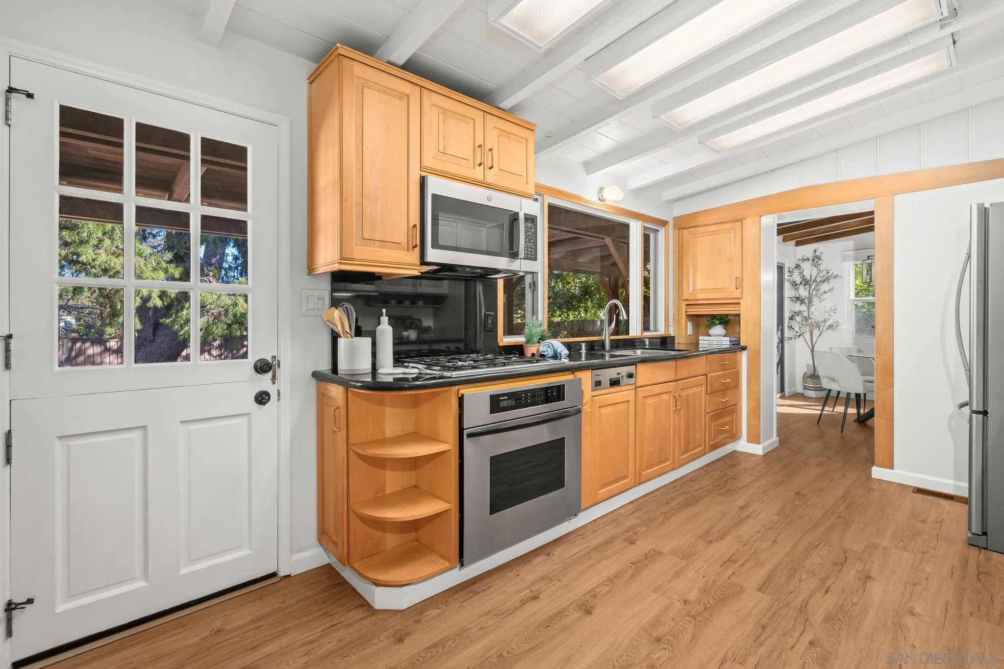 1395 Summit Avenue Cardiff, CA 92007 - Photo 15 of 47 a kitchen with stainless steel appliances kitchen island granite countertop a stove a refrigerator a sink and dishwasher with wooden floor