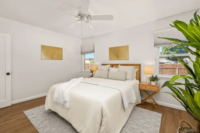 a bedroom with a bed lamp and a potted plant
