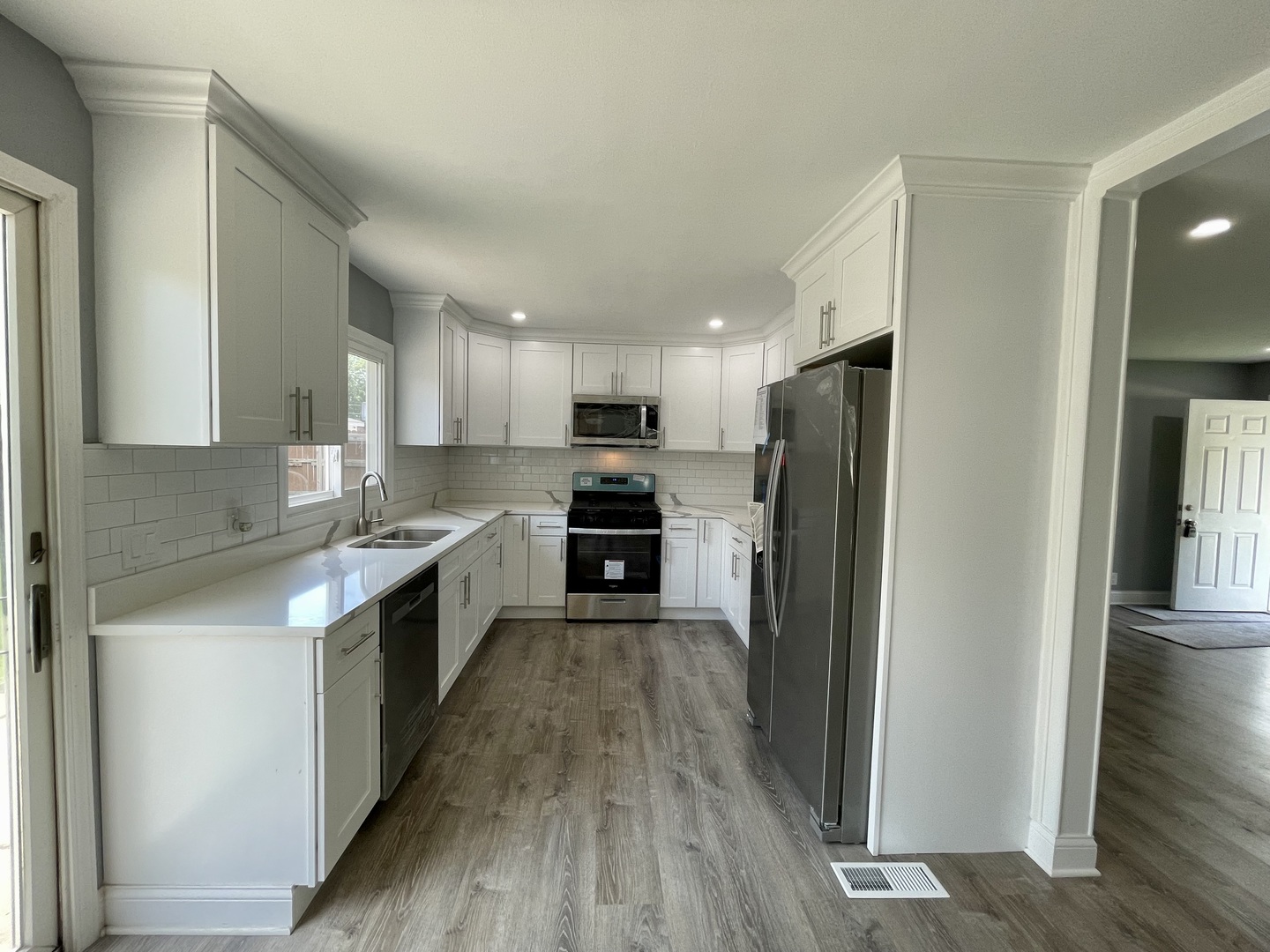 541 Spruce Road Bolingbrook, IL 60440 - Photo 6 of 21 a large kitchen with a center island wooden floor stainless steel appliances and a window
