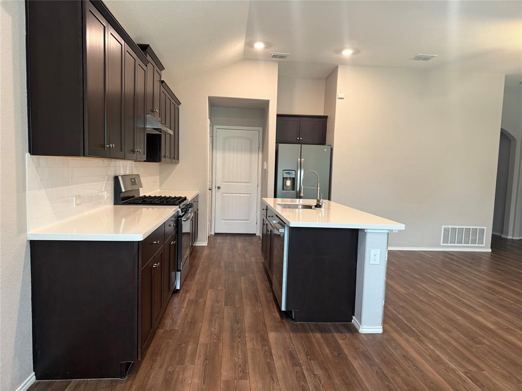 1004 Rising Moon Drive Fort Worth, TX 76052 - Photo 8 of 13 Contemporary kitchen featuring dark wood cabinetry, white countertops, and a subway tile backsplash