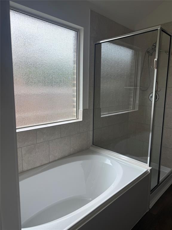 1004 Rising Moon Drive Fort Worth, TX 76052 - Photo 9 of 13 Bathtub with a frosted window, subway tile surround, and an adjacent glass-enclosed shower