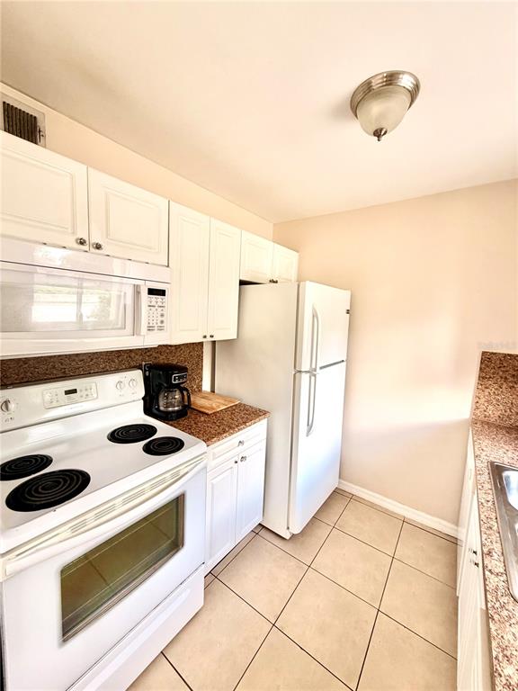 3206 West Azeele Street, Unit 100 Tampa, FL 33609 - Photo 7 of 15 a kitchen with a stove a refrigerator and a cabinets