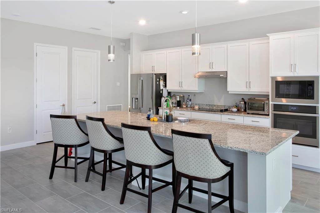 11726 Canopy Loop Fort Myers, FL 33913 - Photo 8 of 40 Kitchen featuring white cabinetry, appliances with stainless steel finishes, a breakfast bar, and recessed lighting