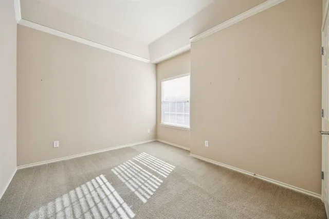 an empty room with ceiling fan and entryway
