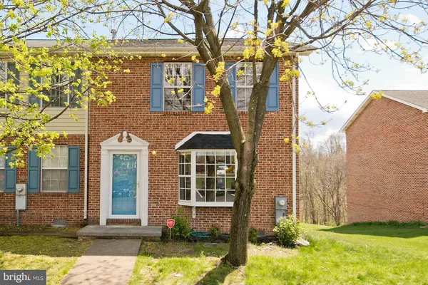 front view of a brick house with a yard