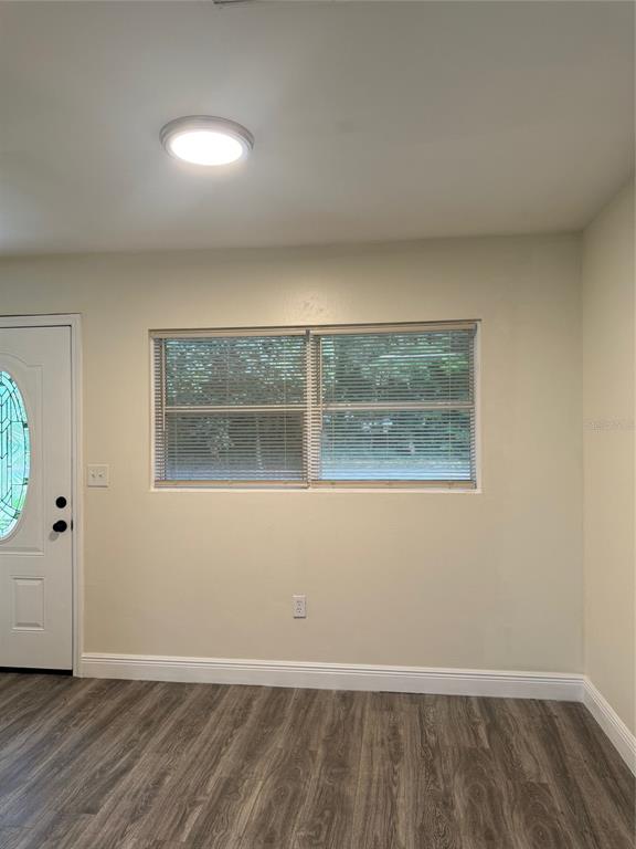34825 Cutoff Road, Unit B Fruitland Park, FL 34731 - Photo 3 of 9 an empty room with wooden floor and windows