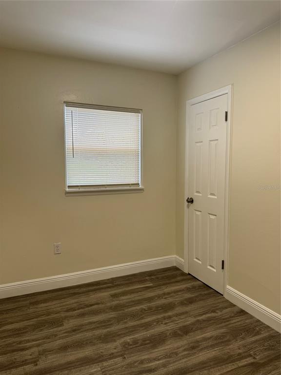 34825 Cutoff Road, Unit B Fruitland Park, FL 34731 - Photo 6 of 9 a view of an empty room with wooden floor and a window