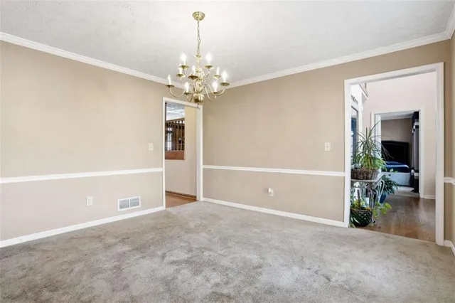 an empty room with chandelier fan