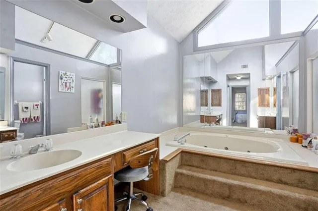 a bathroom with a granite countertop sink and a bathtub
