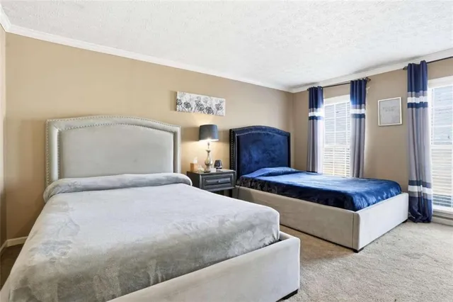 a bedroom with a large bed and a night stand