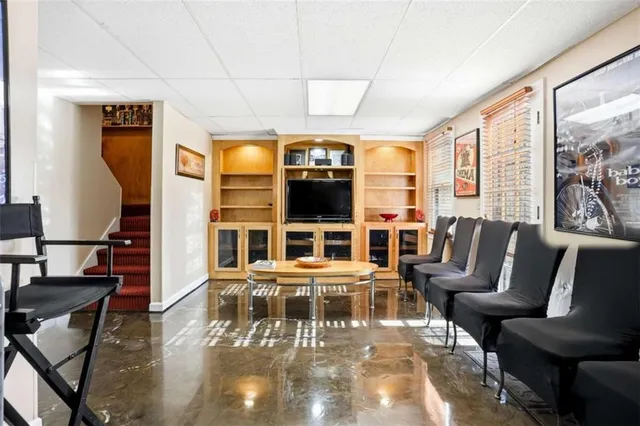 a living room with furniture large window and wooden floor