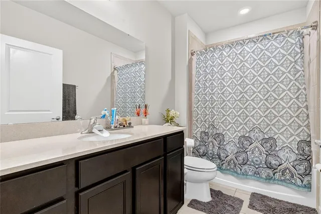 a bathroom with a granite countertop sink toilet and a mirror