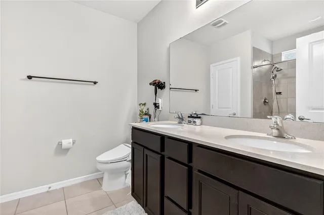a bathroom with a double vanity sink toilet and a mirror