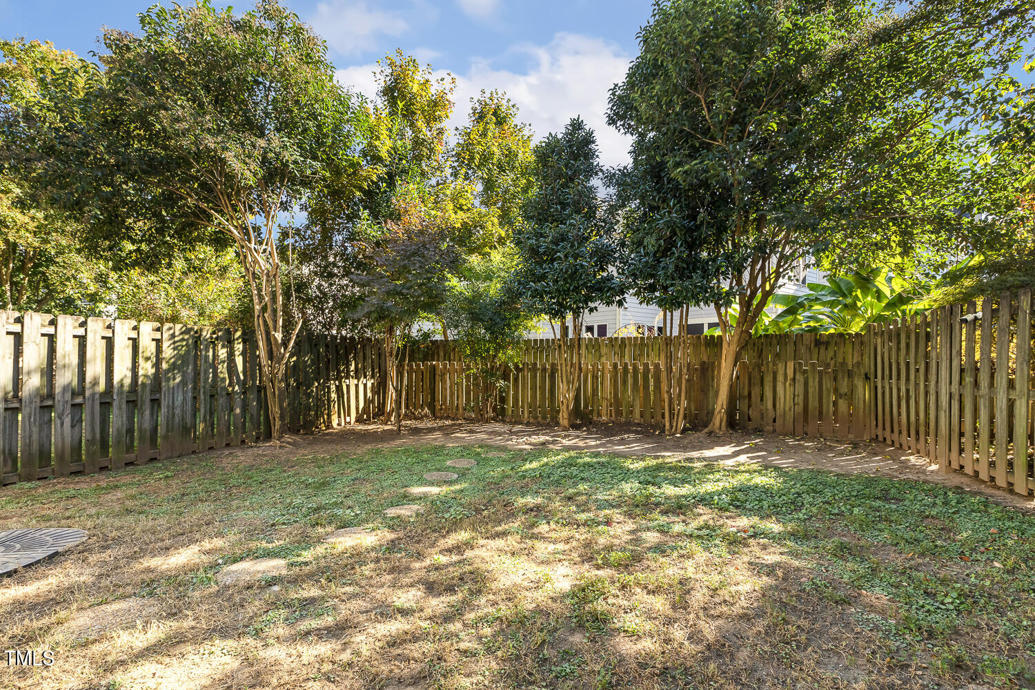616 East Whitaker Mill Road Raleigh, NC 27608 - Photo 13 of 13 a backyard of a house with large trees and wooden fence