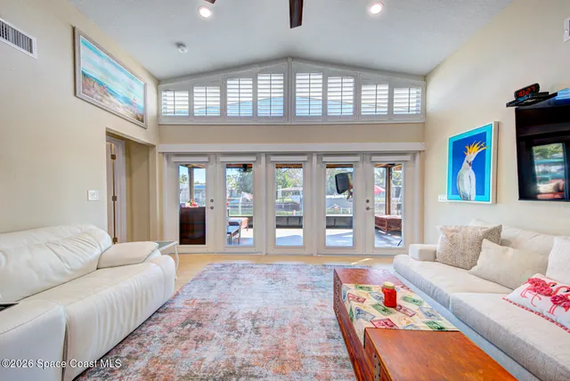 a living room with furniture and floor to ceiling windows