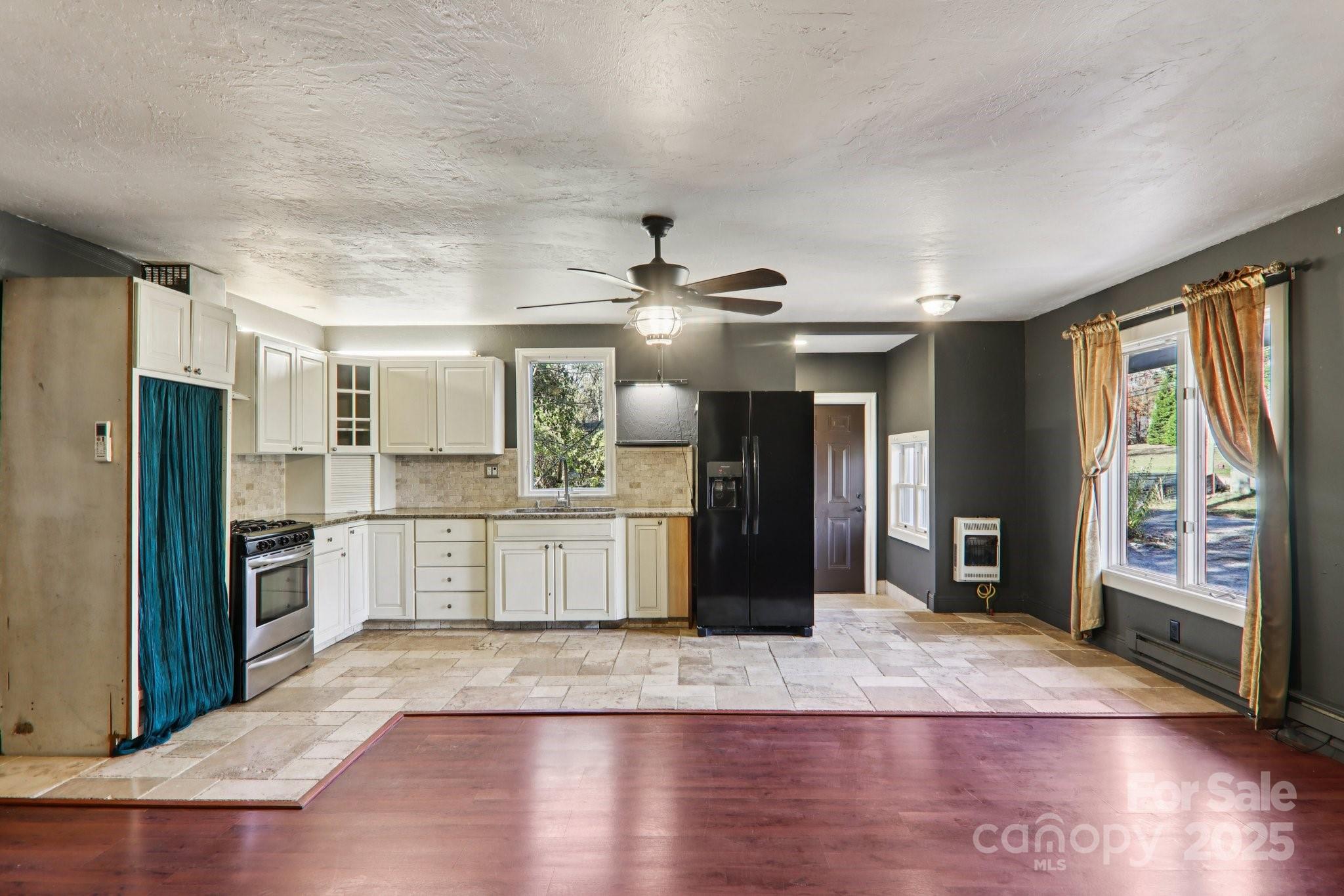 1749 Haywood Road Hendersonville, NC 28791 - Photo 12 of 48 a kitchen with stainless steel appliances kitchen island granite countertop a refrigerator a stove a sink and a large window