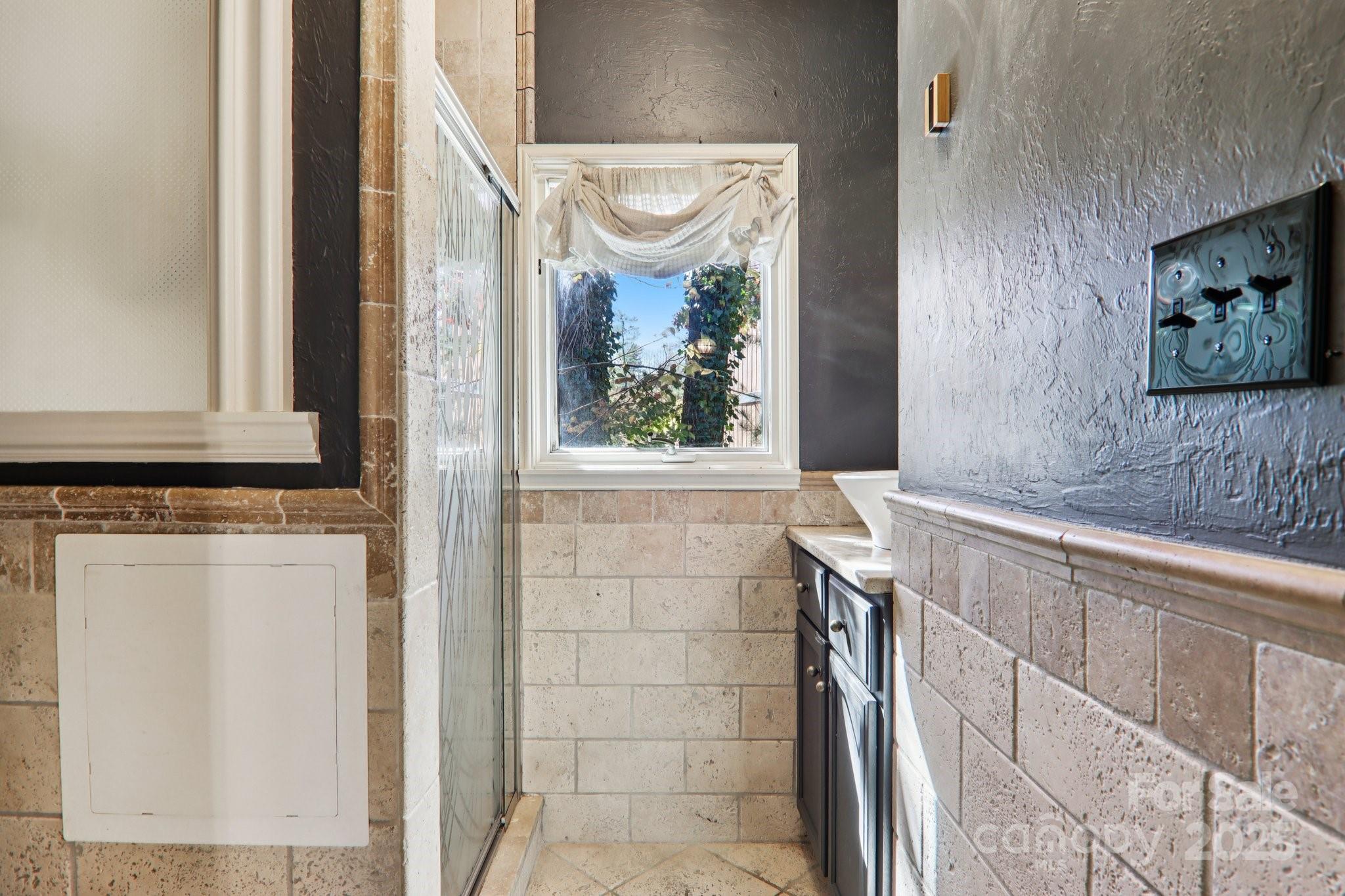 1749 Haywood Road Hendersonville, NC 28791 - Photo 20 of 48 a bathroom with a bathtub and a window