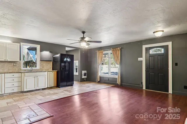 a large kitchen with a wooden floor and chandelier