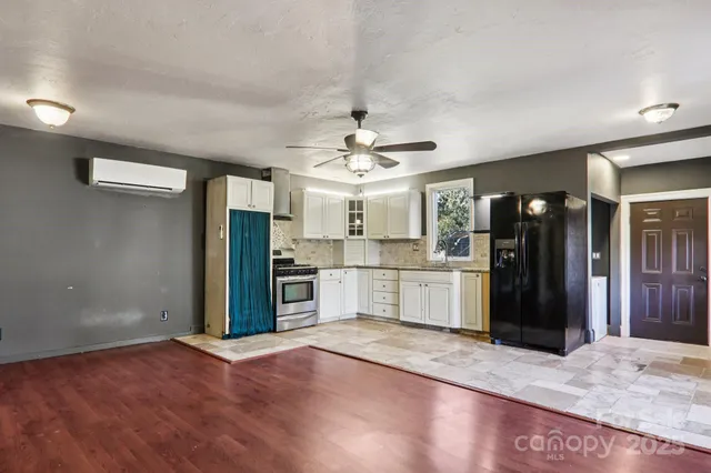 a view of a kitchen with refrigerator and a sink
