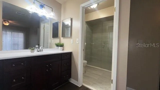 a bathroom with a double vanity sink mirror and shower