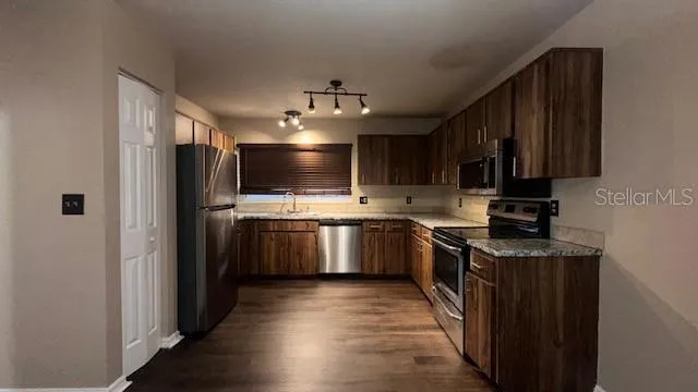 a kitchen with stainless steel appliances a sink stove and refrigerator