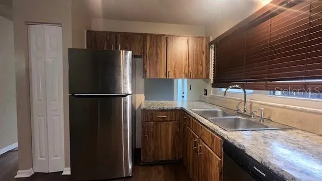 a kitchen with granite countertop a refrigerator and a sink