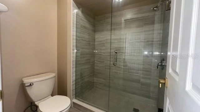 a bathroom with a toilet and a shower