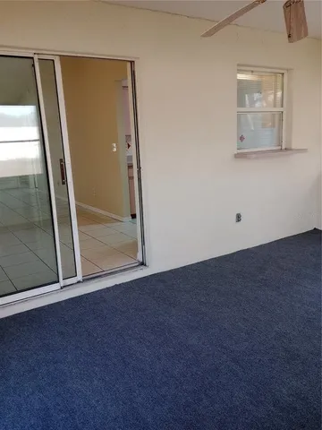 an empty room with windows and ceiling fan