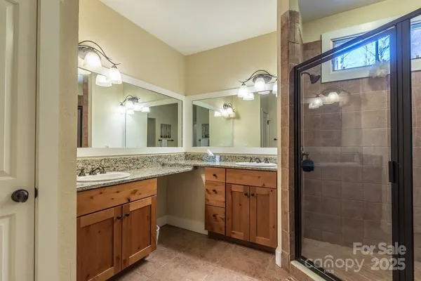 a bathroom with a granite countertop sink mirror and a shower