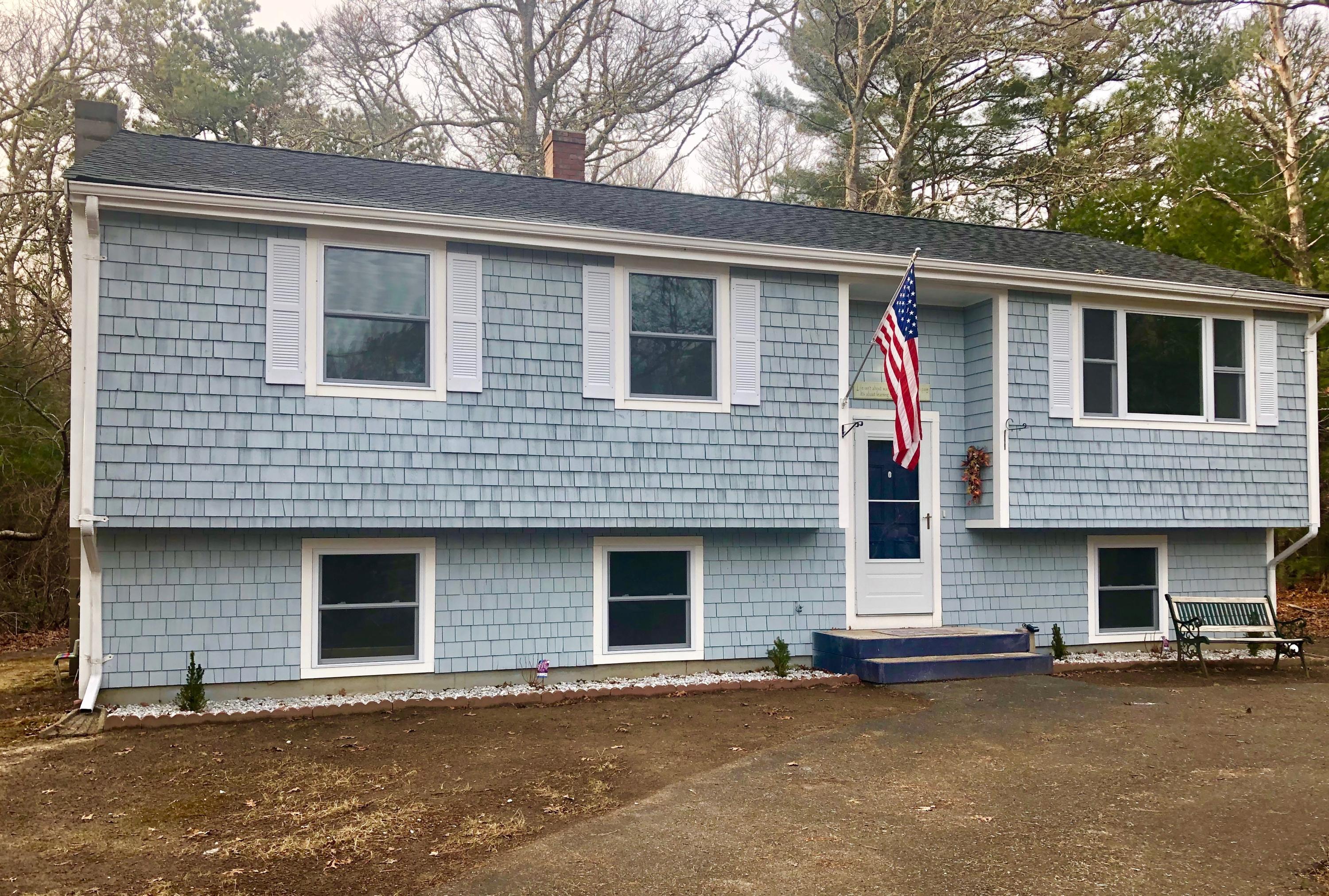57 Stage Coach Road Centerville, MA 02632 - Photo 1 of 34 a front view of a house with yard and parking