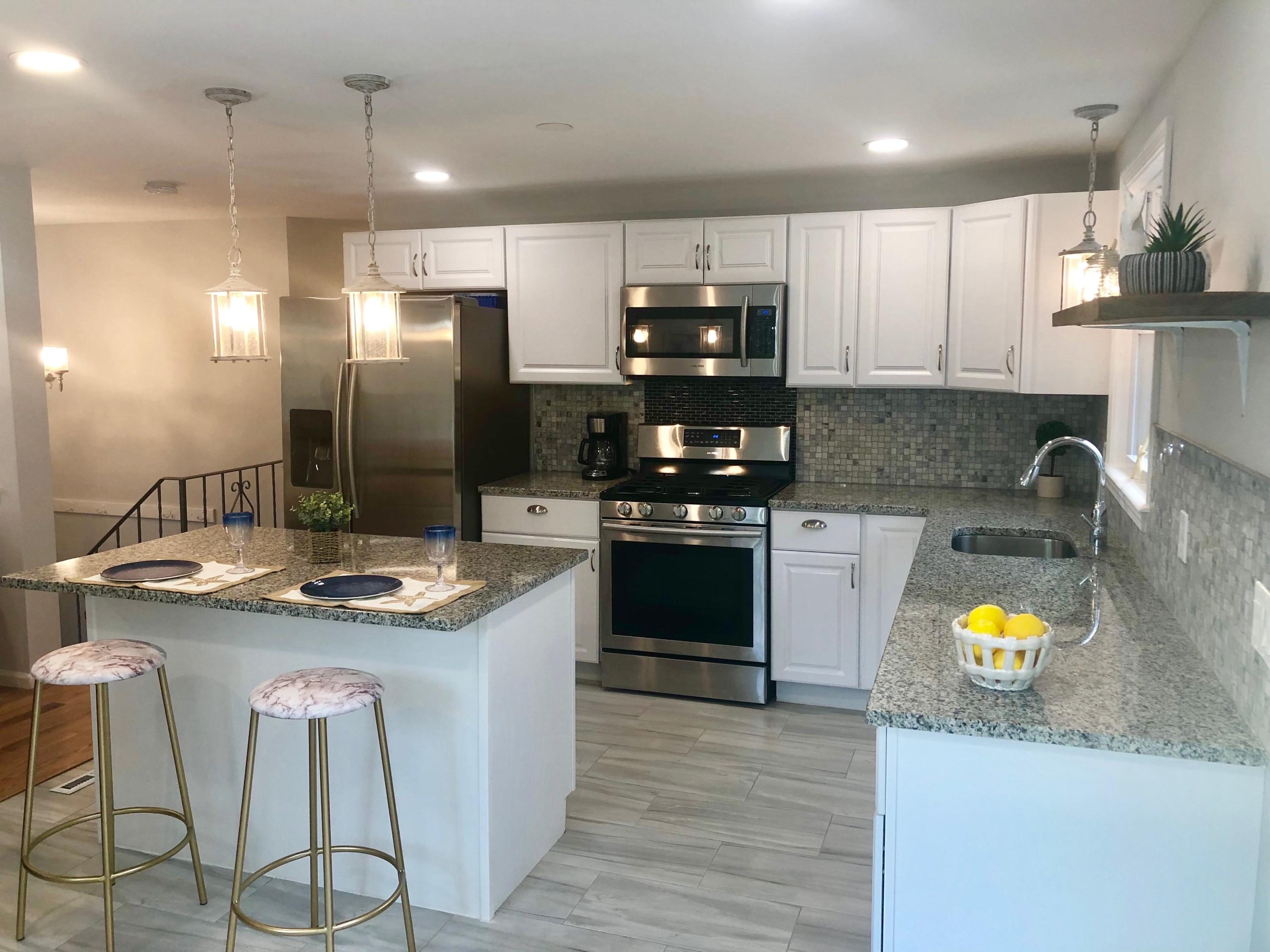 57 Stage Coach Road Centerville, MA 02632 - Photo 8 of 34 a kitchen with stainless steel appliances granite countertop a stove a sink and a microwave