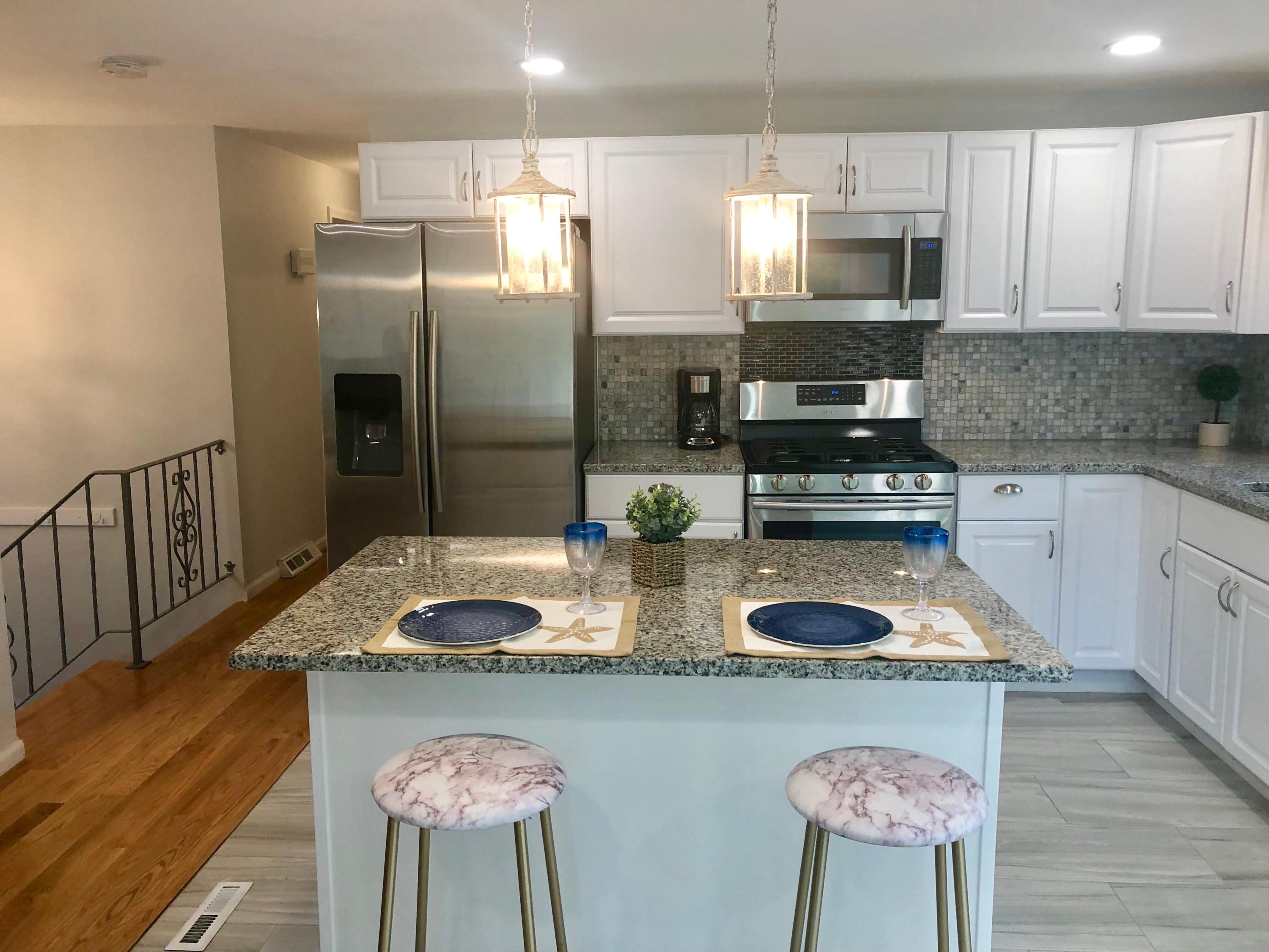 57 Stage Coach Road Centerville, MA 02632 - Photo 9 of 34 a kitchen with stainless steel appliances granite countertop a sink a stove a refrigerator cabinets and wooden floor